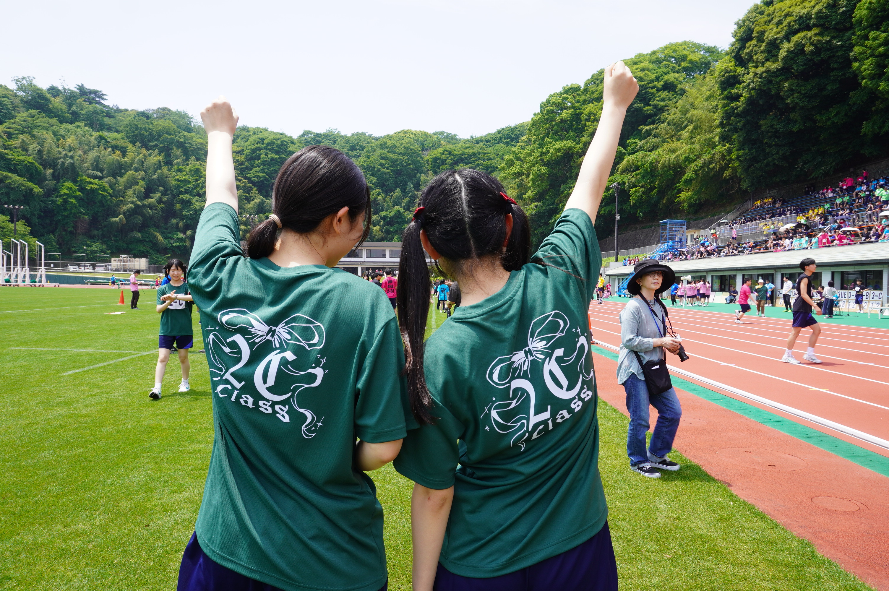 背中合わせで勝利を喜ぶ生徒